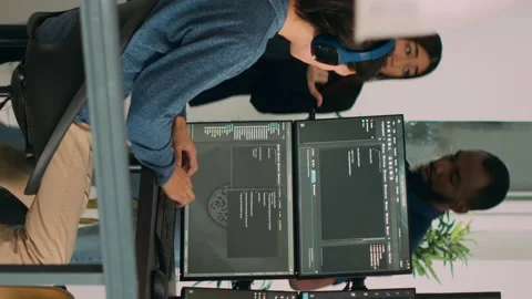 Vertical video: Diverse programmers collaborating on coding project compiling Stock Footage 220104166