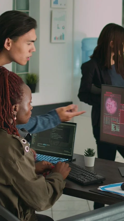 Vertical video: Diverse team of app developers having computer hacked and Stock Footage 218576526