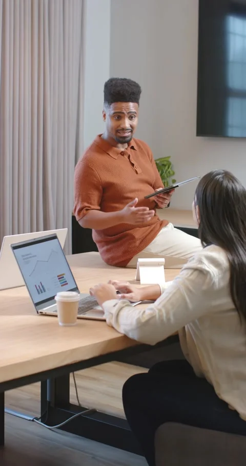 Vertical video: Diverse team seeing man sharing tablet charts to talk while Stock Footage 345093094