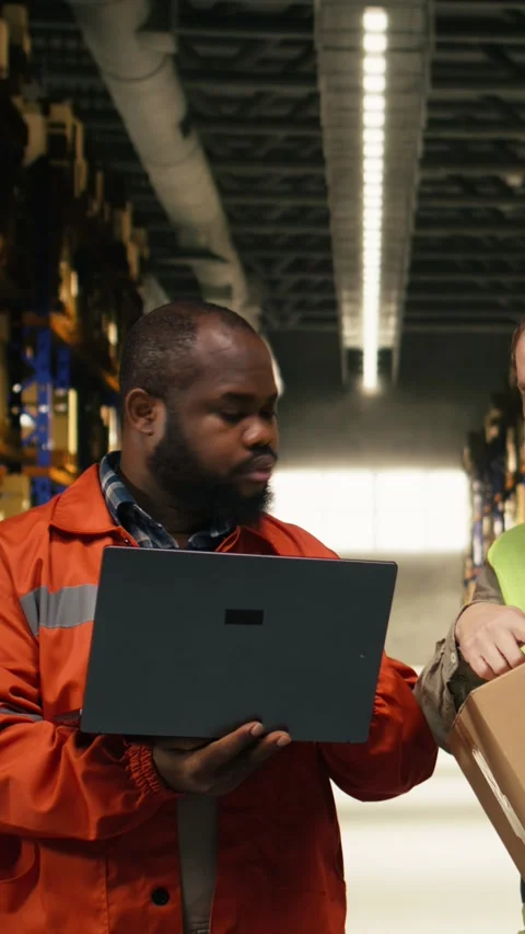 Vertical Video Diverse warehouse team, update parcel tracking software, with Stock Footage 333090013