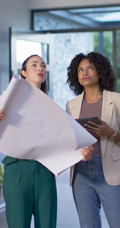 Vertical video: Diverse women checking plan on pad in entry after spotting Stock Footage 345397664