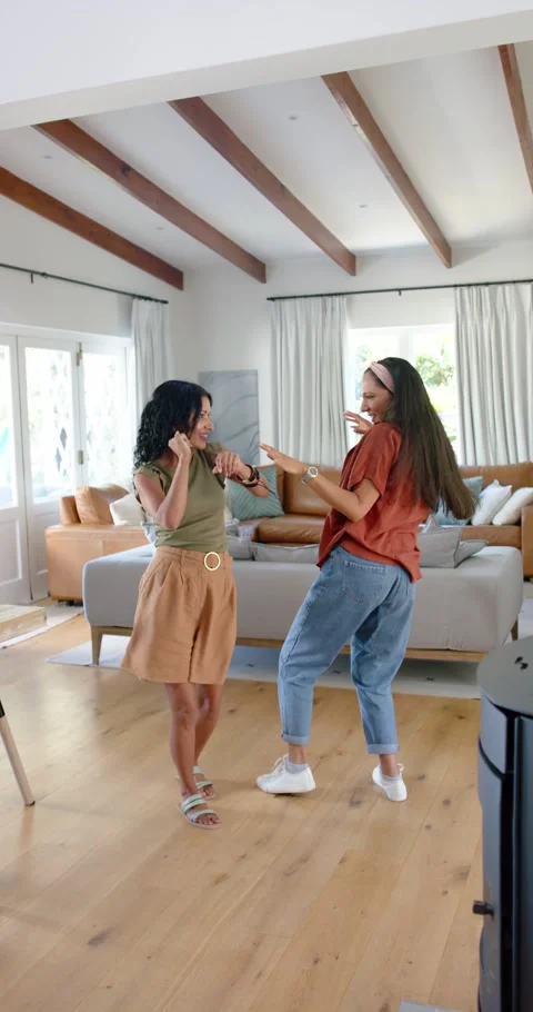 Vertical video: Diverse women dancing in living room by sofa, green starting Stock Footage 345218437