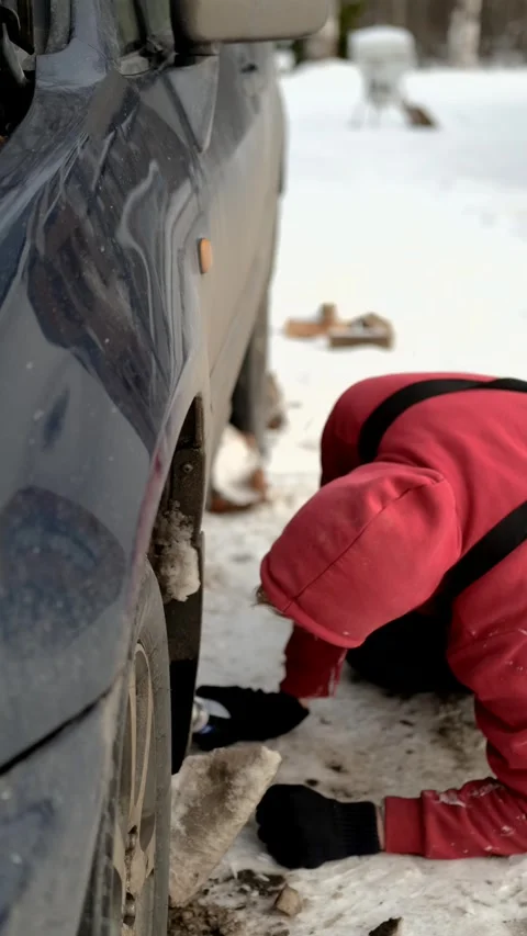 Vertical video, do-it-yourself car repair, man gets under car for inspection Stock Footage 303072080
