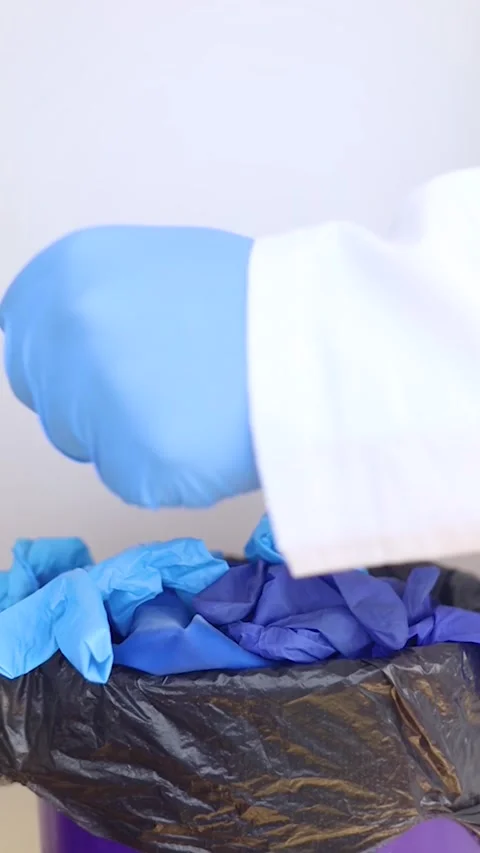 Vertical video.  Doctor throws disposable gloves into trash bin. Medical waste d Stock Footage 286208874