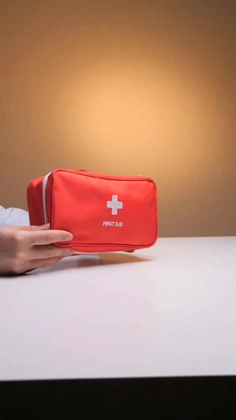 Vertical video doctor's hands holding a red first aid kit with a white cross Stock Footage 324766803