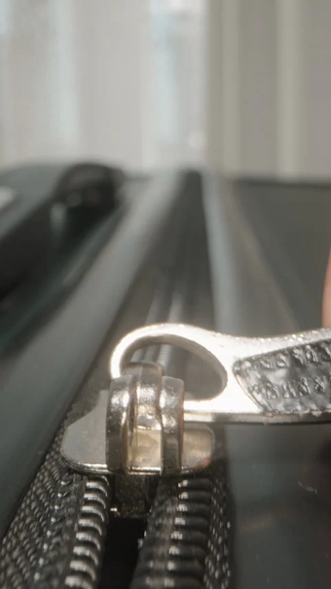 Vertical video. Dolly slider, close up. Fingers pull the zipper shut, securing Stock Footage 282288231