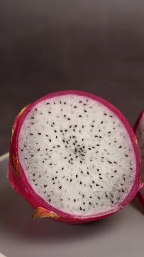 Vertical video, dragon fruit cut in half on a gray plate, travel shot right Stock Footage 281035511