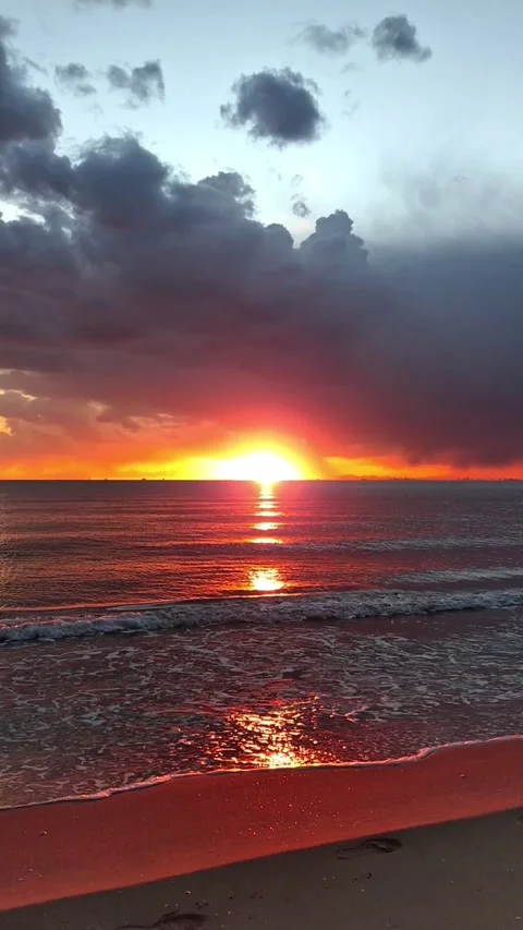 Vertical Video of Dramatic Red Sunset Over Sea with Dark Clouds Stock-Footage 337679571