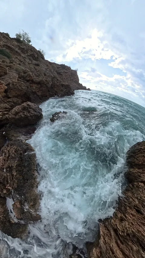 Vertical video. A dramatic slow-motion shot with a tiny planet effect of waves 스톡 동영상 293684157