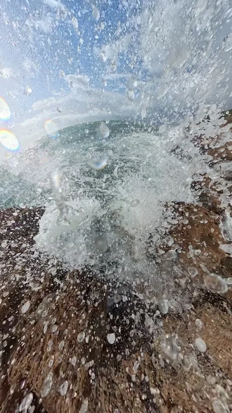 Vertical video. A dramatic spherical perspective of waves crashing into jagged Stock Footage 294110052
