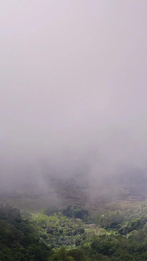 Vertical video. Dramatic View of Gunung Batur Volcano Partly Hidden by Low Cloud Stock Footage 336693504
