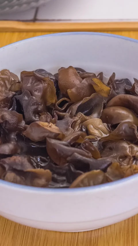 Vertical Video: Dried wood ear mushrooms expand after soaking in water Stock Footage 340538423