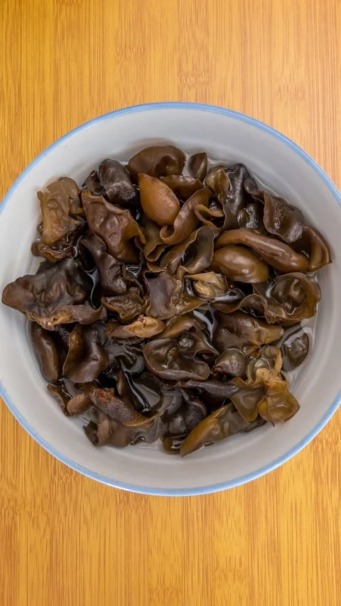 Vertical Video: Dried wood ear mushrooms expand after soaking in water 스톡 동영상 340540743