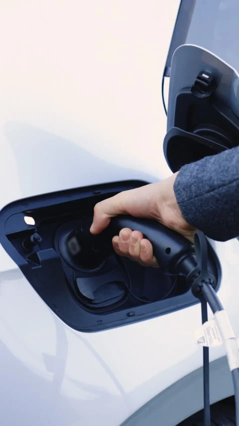 Vertical Video of The driver of the electric car inserts the electrical Stock Footage 306605940