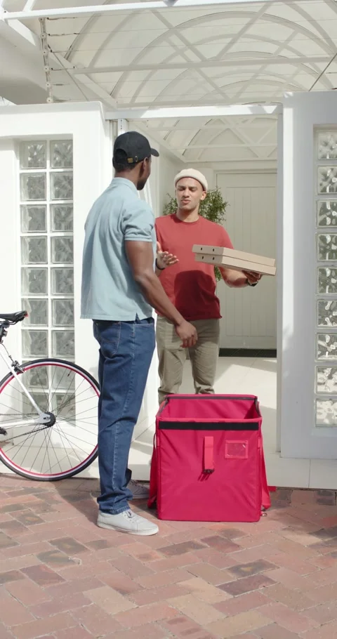 Vertical video: Driver loading boxes into red thermal bag as owner handing them Stock Footage 346718727