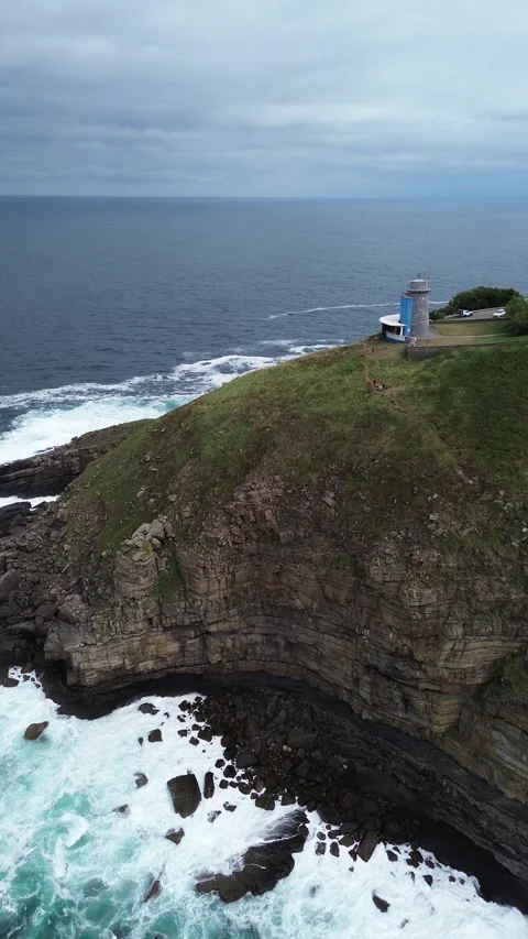 Vertical video, drone flying along the sea and cliffs to the lighthouse in North Stock Footage 282295793