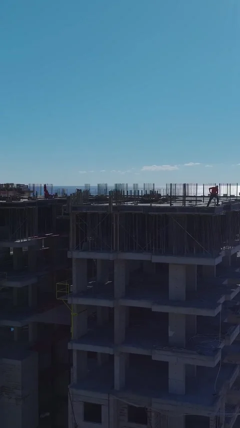 Vertical Video Drone View of Rooftop Construction with Worker and Reinforcement Stock Footage 342471091