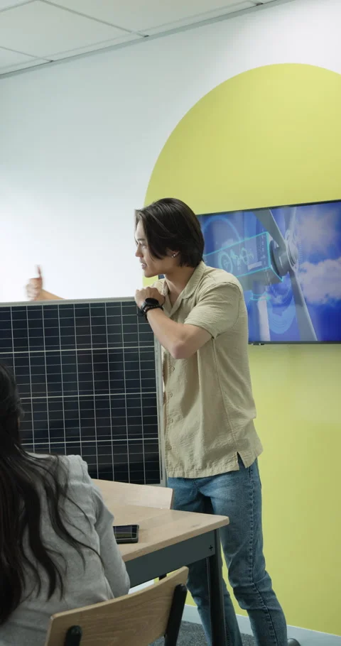Vertical video: During office meeting Asian man showing solar panel size and Vidéo 313168758
