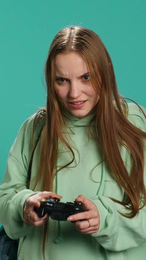Vertical video Ecstatic young girl using controller, excited after being Stock Footage 276335018