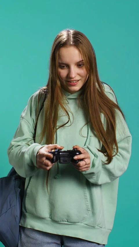 Vertical video Ecstatic young girl using controller, excited after being Stock Footage 276335128