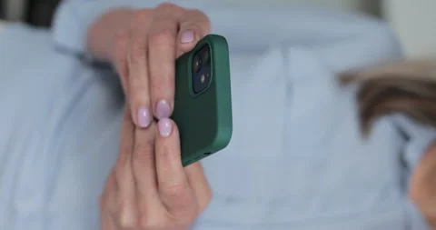Vertical video. Elderly woman browsing online on smartphone. Stock Footage 334069855