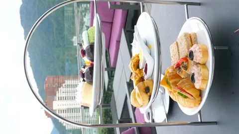 Vertical video of elegant afternoon tea setup, complete with tiered trays Stock Footage 233143100