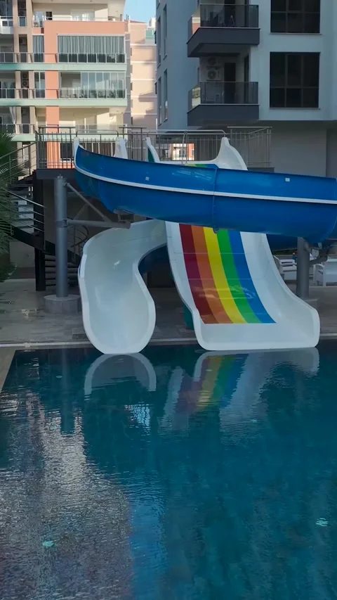 Vertical Video: Elegant Complex with Beautiful Pools, Kids Slides, and a Unique Stock Footage 297756293