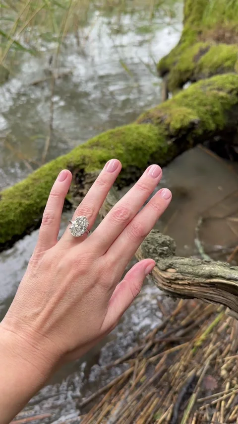 Vertical video of elegant hand with oval diamond ring over water Video stock 316843519