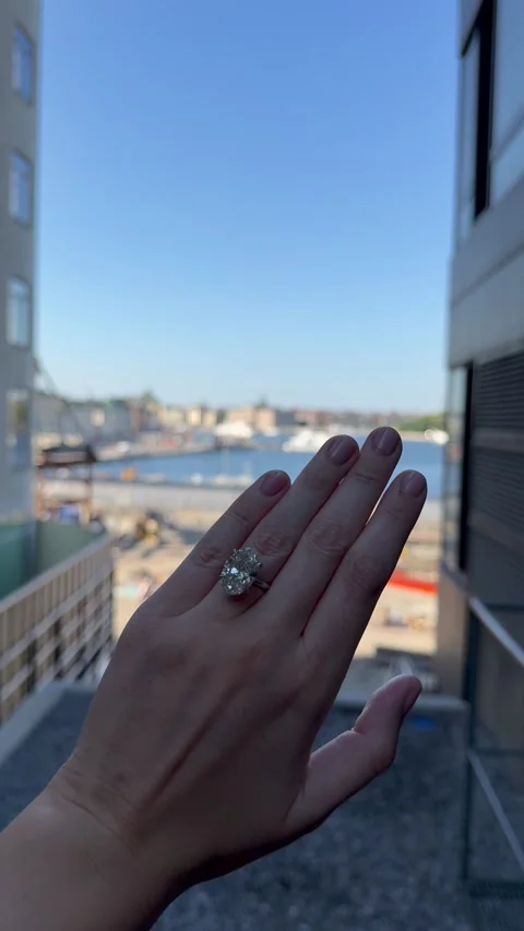 Vertical video of elegant hand with solitaire engagement ring in city light 스톡 동영상 317098073