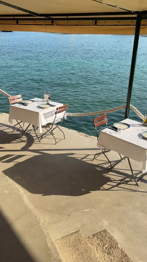 Vertical video of elegant lunch table setting by the Mediterranean water 스톡 동영상 319401224