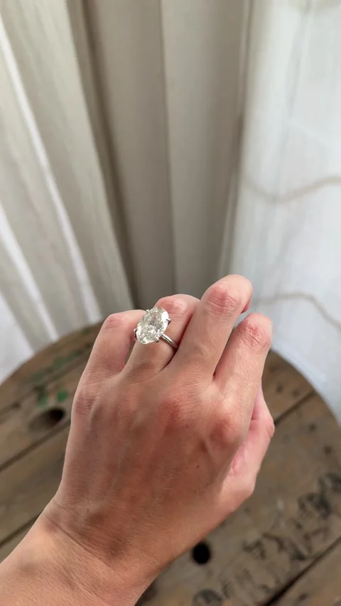 Vertical video elegant oval diamond engagement ring behind curtains Stock Footage 319457042