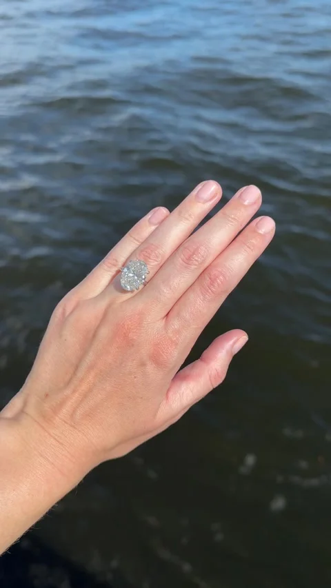 Vertical video of elegant solitaire engagement ring hand by waterfront Stock Footage 317335605