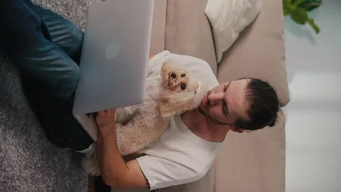Vertical Video. Emotional Support, Remote Work. Man in Online Call with Dog Stock Footage 311552957