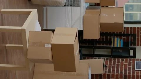 Vertical video: Empty apartment flat full of moving unpacked cardboard boxes Stock Footage 194878761