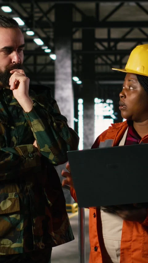 Vertical Video Engineer and military officer reviews production to support Stock Footage 330139070