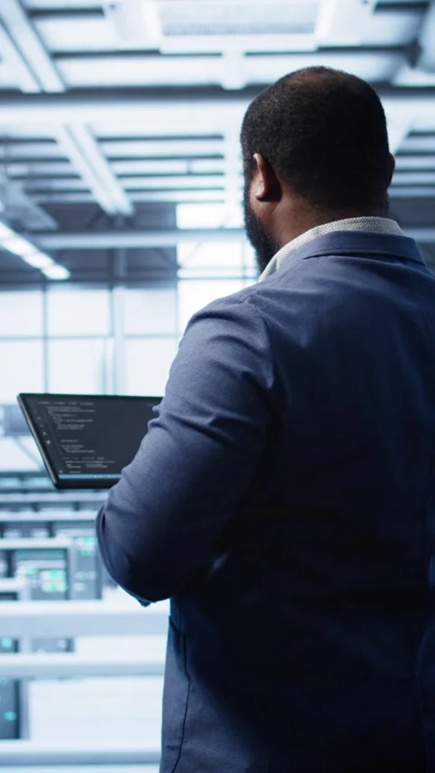 Vertical video Engineer in data center fixing errors affecting server rows rigs Stockbeeldmateriaal 277857370