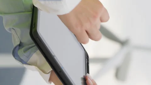 Vertical video. Engineer with electronic tablet near windmill: technical Stock Footage 254112627