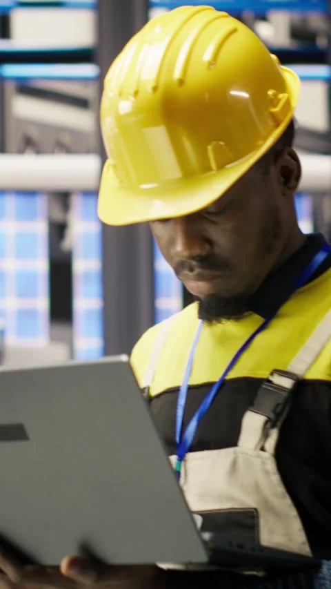 Vertical video Engineer in smart factory implementing renewable energy solutions Stock Footage 307146035