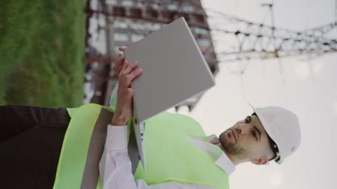 Vertical Video. Engineer Working Outside in Hard Hat and Vests Inspects Power Stock Footage 242404346