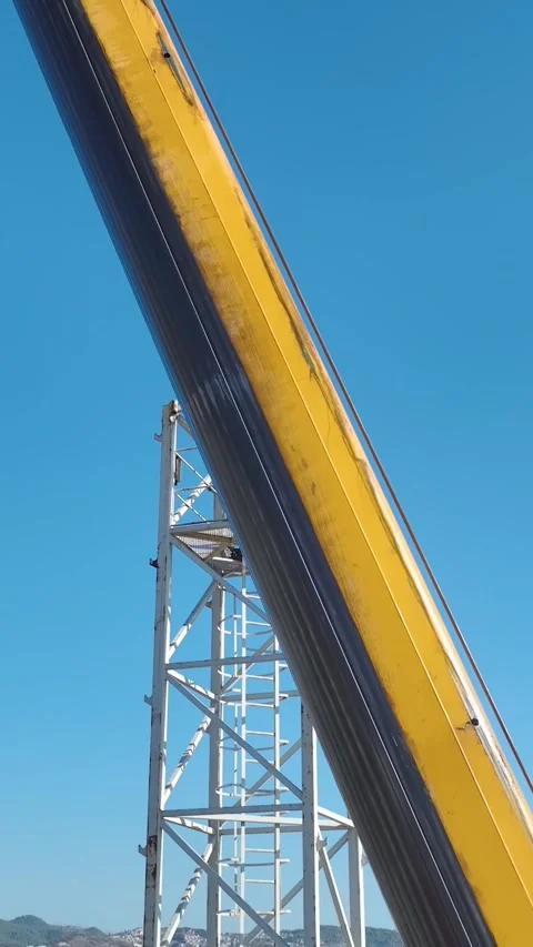 Vertical Video: Engineers Handling Tower Crane Parts On A Busy Worksite Captured Stock Footage 297704131