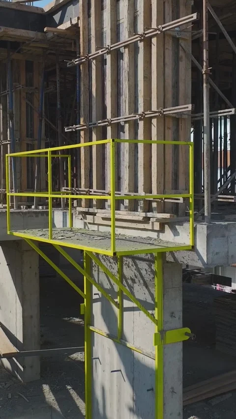 Vertical Video: Engineers Oversee Plans While Teams Use Concrete and Metal to Stock Footage 342912586