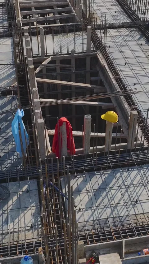 Vertical Video: Engineers Review Plans While Workers Build Walls, Pour Concrete Stock Footage 342914862