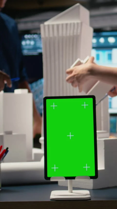 Vertical Video Engineers team share master plan ideas next to chroma key display Stock Footage 316186362