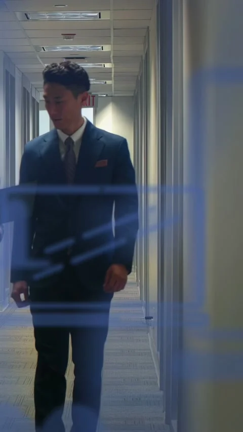 Vertical video: Entering left, pair walking hall, woman showing folder, man in Stock Footage 333006003