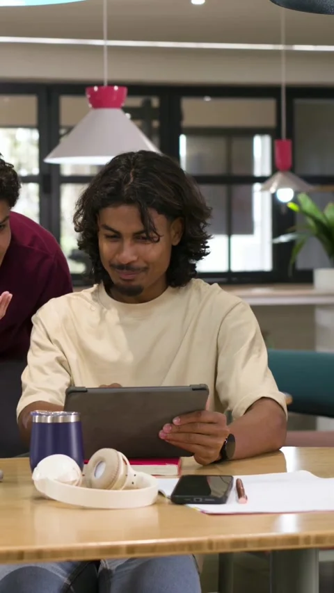 Vertical video: Entering left, peer pointing tablet, beige tee man tapping, Stock Footage 348727670