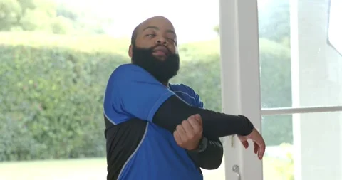 Vertical video: Entering man in top with compression sleeve pulling arm across Stock Footage 336438118