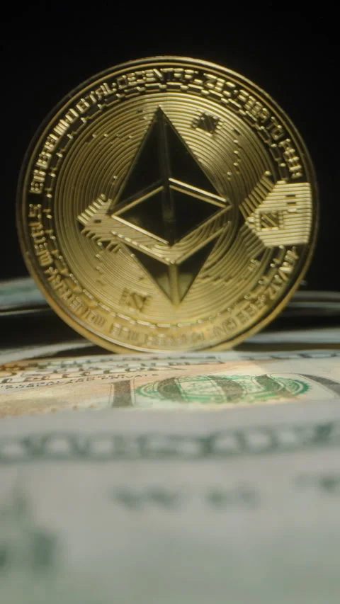 Vertical video. Ethereum Coin in Soft Focus Positioned on a Stack of US Dollar Stock Footage 296562861