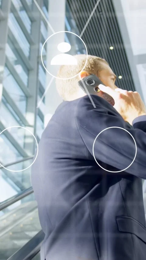 Vertical video: Exec on escalator raising phone and calling bringing tech icons Stock Footage 335513208