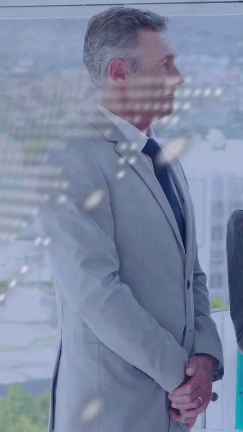 Vertical video: Exec standing, dotted code drifting over him, camera showing Stock Footage 333464912