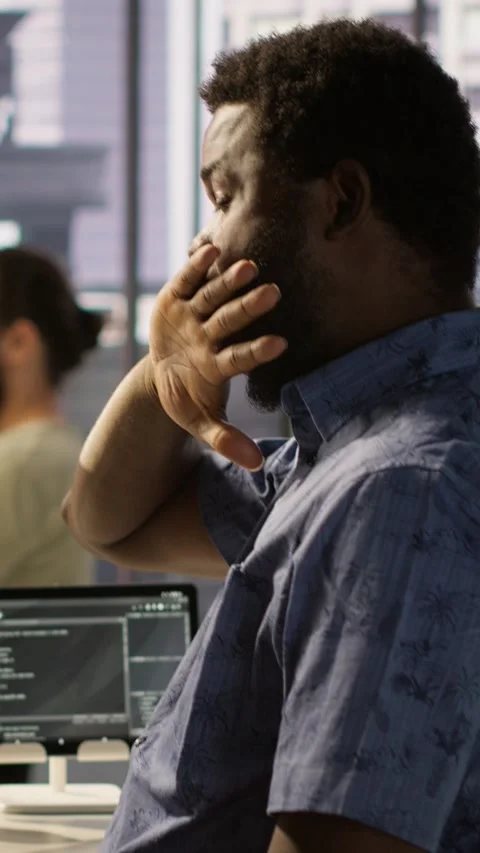 Vertical video Exhausted man being sleepy in workspace, programming on computer Stock Footage 319485516